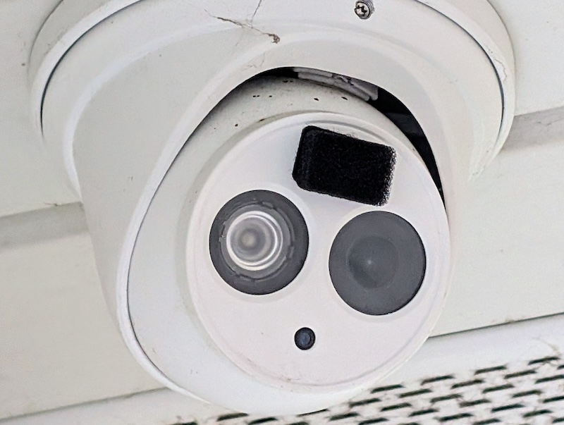 An Amcrest security camera with a black action-camera windscreen installed.