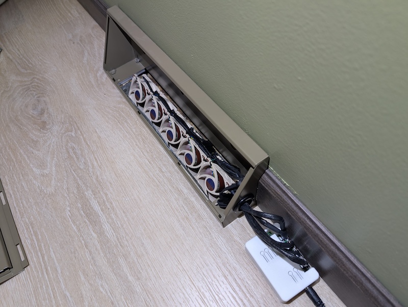 An array of 5 Noctua NF-A6x25 fans stuffed into an HVAC duct pointed diagonally upward into a baseboard vent along a bedroom wall.
